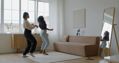 Two African-American Black girls recording trendy dance moves for social media account