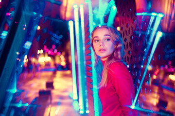 Beautiful. Cinematic portrait of stylish young woman in neon lighted room. Bright neoned colors. Caucasian model, musician outdoors. Youth culture in party, festival style and music concept.