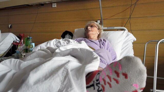 Old sick lady lying in hospital bed