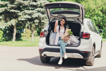 Portrait of her she nice attractive cheerful lady sitting in trunk carrying fresh cooking ingredients vegan vegs bio farm supply taking making selfie having fun outdoor outside