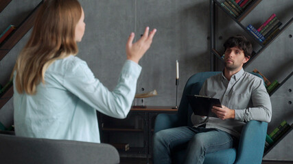 Positive psychoanalyst man conversation with female patient in office room. People, dialogue and...