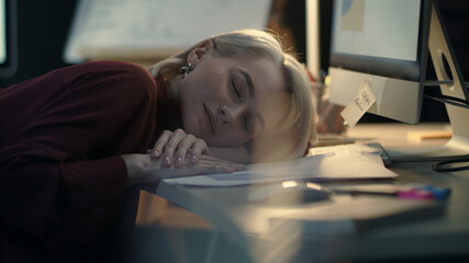 Exhausted business woman lying down on computer table at night work in office © stockbusters