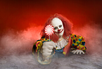 scary clown with a lolly is rising from the sewer