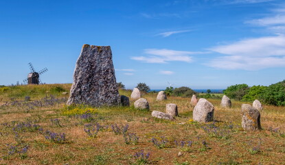 Viking stone ship burial and old windmill in Oland island by beautiful day, Gettlinge, Sweden © Elenarts