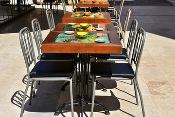 Open Air Cafe in old town in Pula, Croatia. No people, selective focus. empty served table in outdoor cafe.  Interior of a popular cafe at sunny day
