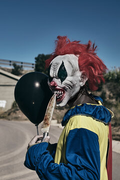 Scary Clown With A Balloon And A Big Knife