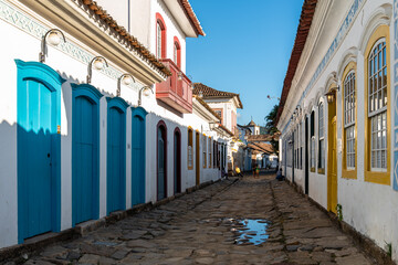 View of narrow street in brazilian colonial town with a water puddle on the pavement