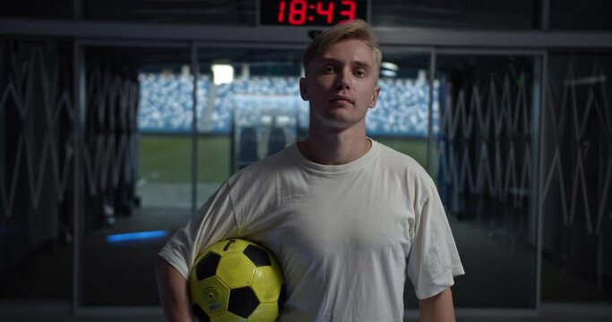Portrait of young Football coach. Soccer football training session, Football tactic education. Man with ball in stadium near field, professional football team staff