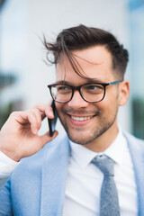 Successful young man having phone conversation outdoor