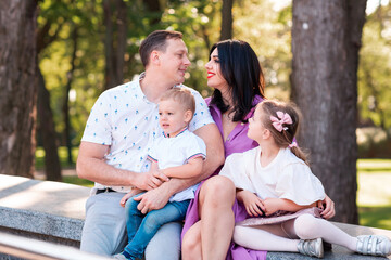 Fototapeta premium Happy young family with two kids walking in the park