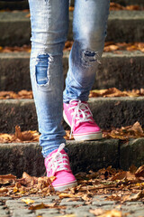 Woman in pink / purple canvas vintage shoes and blue jeans.