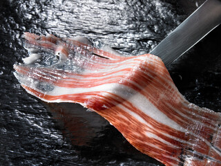 Jamón ibérico sobre fondo negro con cuchillo