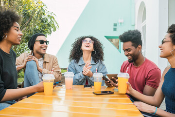 Afro friends having fun together while drinking fruit juice.