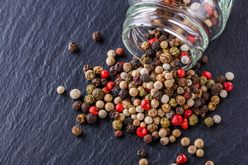mix of peppercorns on a dark stone background