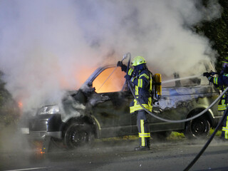 Feuerwehr im Einsatz und löscht brennendes Fahrzeug