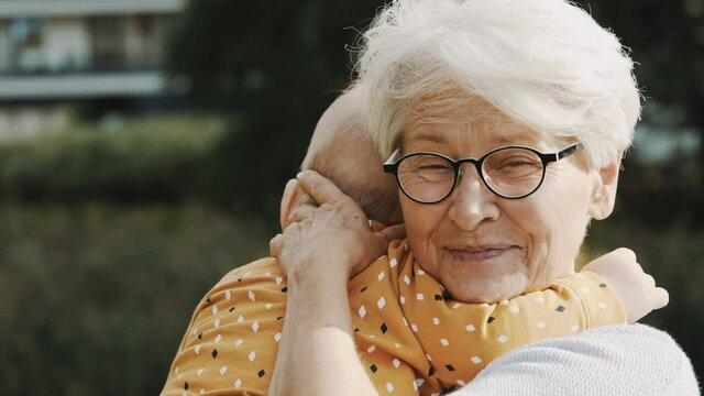 close up, happy grandmother embracing her grandson in nature. High quality 4k footage