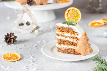 Christmas or New Year gingerbread cake with white cream decorated with gingerbread cookies, fir...