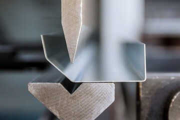 Fototapeta Bending of galvanized sheet metal on a hydraulic bending machine at the factory. obraz
