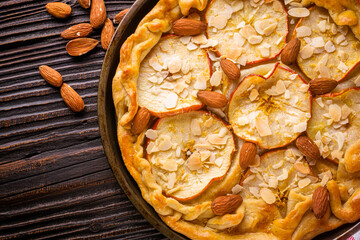 crispy apple galette with almonds on rustic wooden background