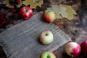 Autumn wooden background with dry leaves and ripe apples. Fall.
