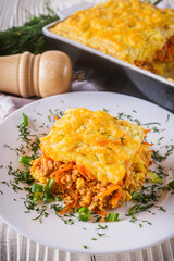Delicious potato casserole with meat and cheese on a white wooden background