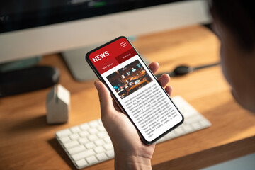 Online news on a smartphone. Mockup website. Woman reading news or articles in a mobile phone screen application at home. Newspaper and portal on internet.