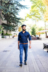 Young Indian man walking in the street.