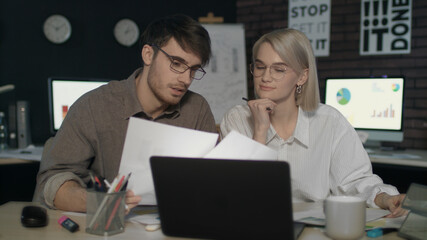 Fototapeta na wymiar Business couple working together with document data front laptop in night office