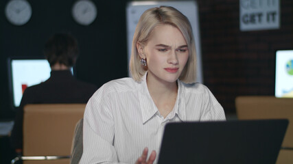 Frustrated business woman working in late office. Upset woman in night offic
