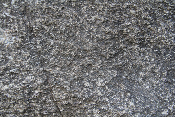 A stone surface with cracks, spots, irregularities. Heterogeneous natural texture. Stock photo for web and print with empty space for text and design, backgound, wallpaper, scrapbooking