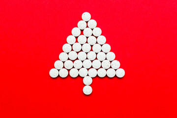 Christmas tree silhouette made of white flat tablets on a red background