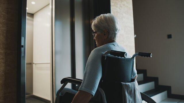 elderly disabled woman using the lift in the wheelchair. High quality photo