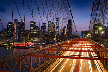 Fototapeta na wymiar Lower Manhattan skyscrapers at Dusk and Brooklyn Bridge with light trails. Evening in New York City, NY, USA