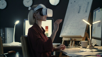 Modern business woman wearing virtual reality glasses in night office
