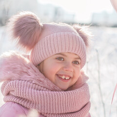 Little girl plays in the winter forest