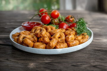handmade tortellini with tomatoes and thyme greens on a white plate is called taralli. taralli in Italian bakeries in southern Italy on a wooden background