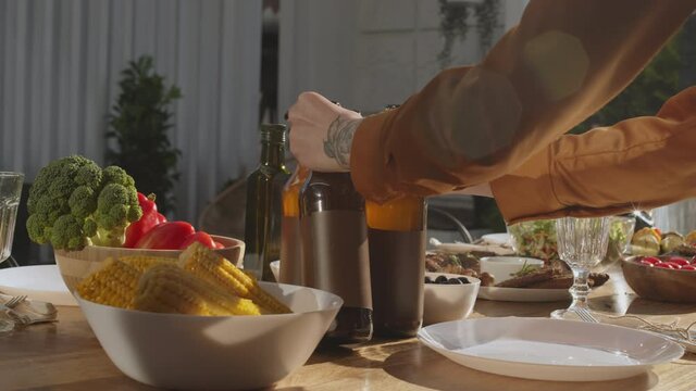 Close up of unrecognizable woman is putting few beer bottles on the dining table in restaurant