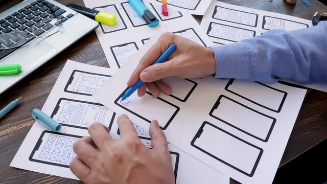Man is designing a ux user experience design for mobile app for a startup.