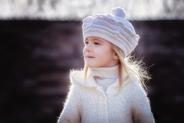 Little blonde girl posing in coat in autumn