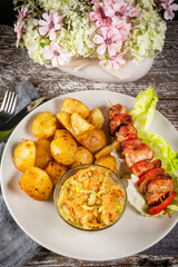 Shish kebab served with roasted potatoes and salad.