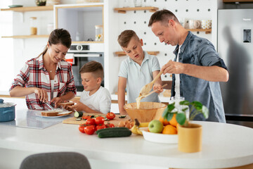 Mother and father making breakfast with sons. Young family preparing delicious food in kitchen...