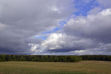 Fototapeta na wymiar September panorama of collective farm fields and copses. Autumn bad weather in the foothills of the Western Urals.