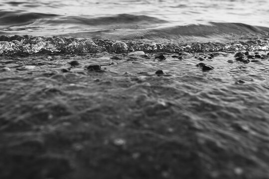 Close-up of water texture, smooth waves of water on the shore, landscape photo of water 