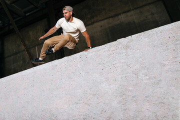 Extreme parkour training in an urban environment, young tracer and freerunner is jumping over...