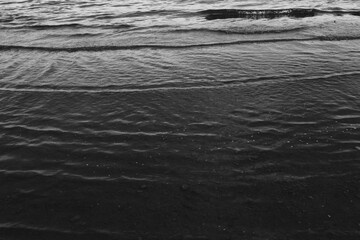 Close-up of water texture, smooth waves of water on the shore, landscape photo of water 