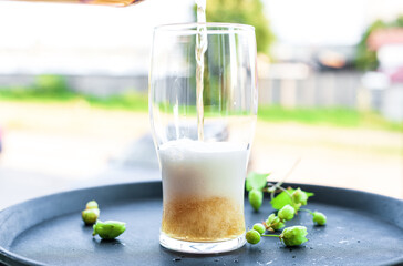 Light golden beer poured into glass from bottle