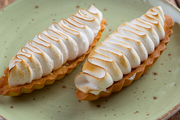 Lemon tart with meringue on green plate