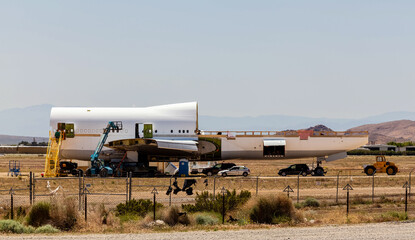 An aircraft bone yard disassembles a jumbo jet piece by piece to be reused or recycled.
