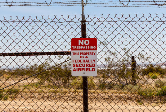 A No trespassing sign posted on the perimeter fence at the Mojave Air & Space Port, Chaffee, California