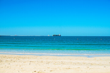 Fototapeta na wymiar Beautiful public beach with turquoise water and a white sand in Persian Gulf shoreline, Dubai.